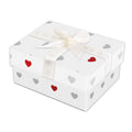 A square white gift box with a lid, decorated with small scattered red and gray hearts and tied with a white satin ribbon bow, shown on a plain white background.