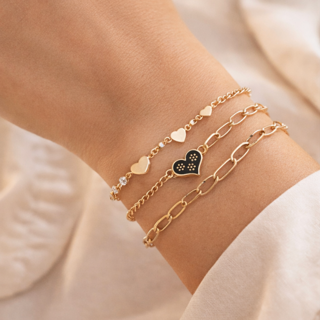 Gold bracelets on a wrist with a soft beige background