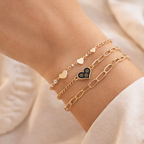 Gold bracelets on a wrist with a soft beige background