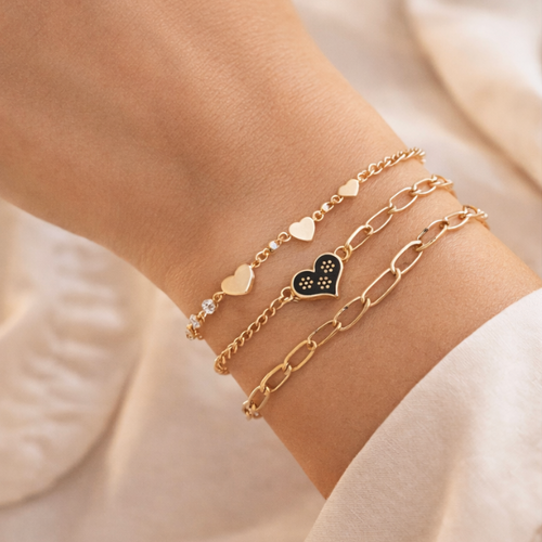 Gold bracelets on a wrist with a soft beige background