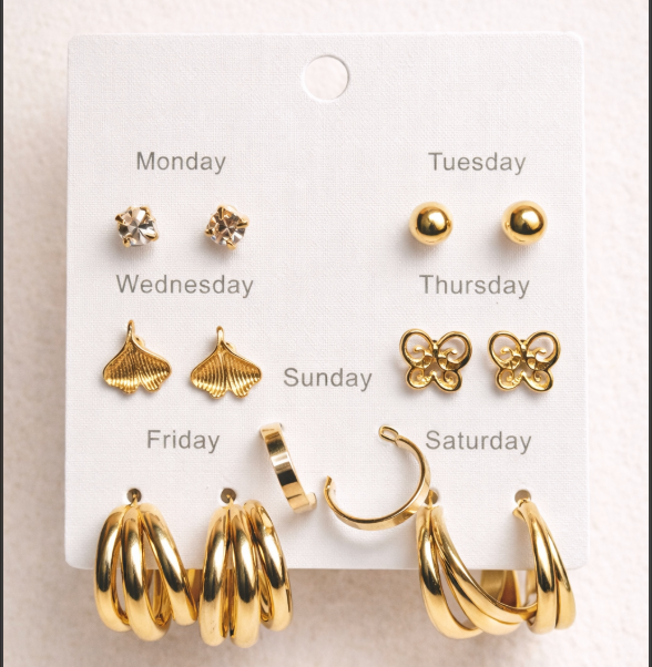 Set of gold earrings on a card labeled for each day of the week.