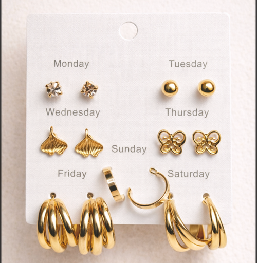 Set of gold earrings on a card labeled for each day of the week.