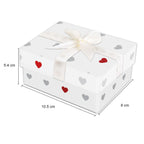 A white gift box with a white satin ribbon and bow, decorated with small gray and red hearts, shown with dimension lines indicating 10.5 cm length, 8 cm width, and 5.