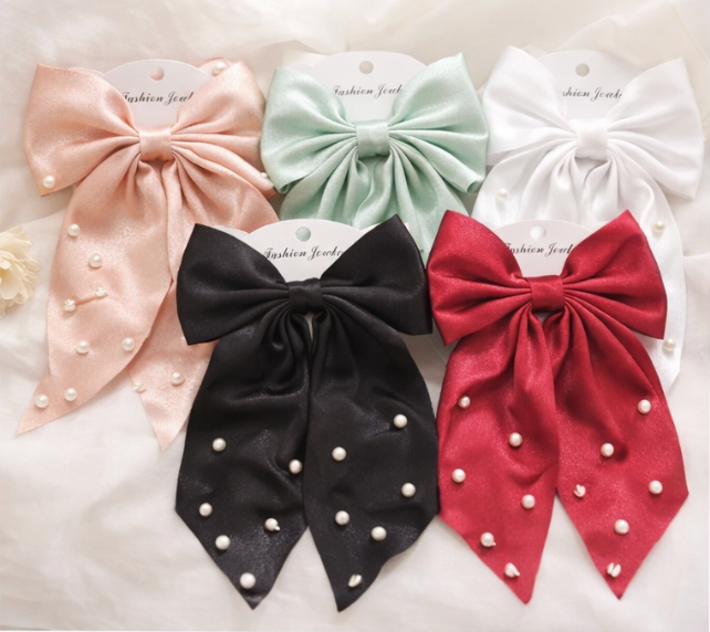 5 pearl bow hair clips in black, red, beige, mint green and white satin ribbon displayed on white background