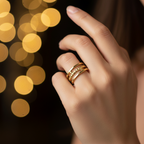 Gold triple layer open cuff ring worn on finger with warm golden bokeh