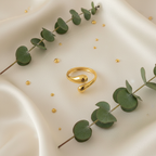 Gold teardrop dome bypass open cuff ring on ivory silk with gold droplets and eucalyptus