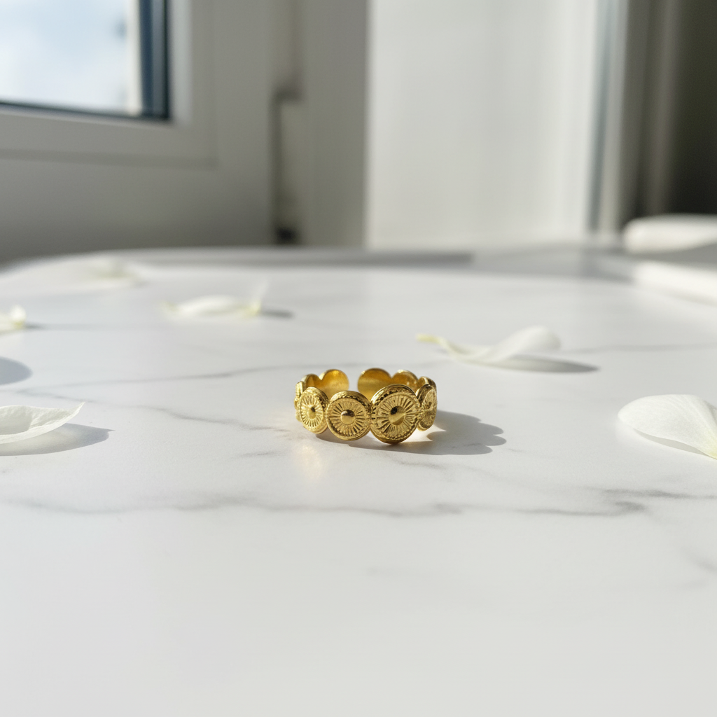 Gold coin ring on white marble surface