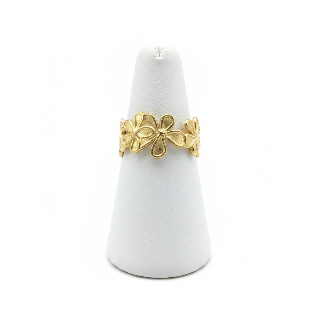 Gold flower bloom open cuff ring on white jewelry stand, clean studio shot