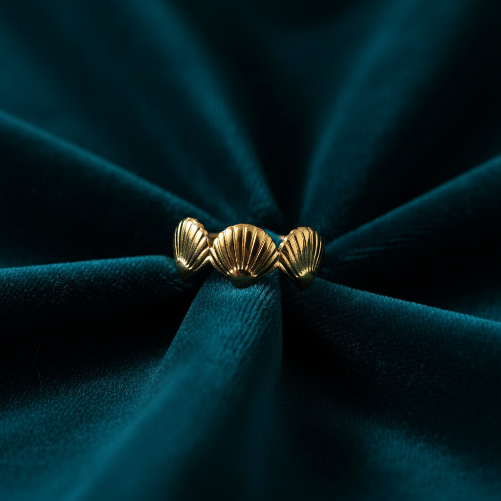 Gold triple seashell ring on ocean teal velvet fabric