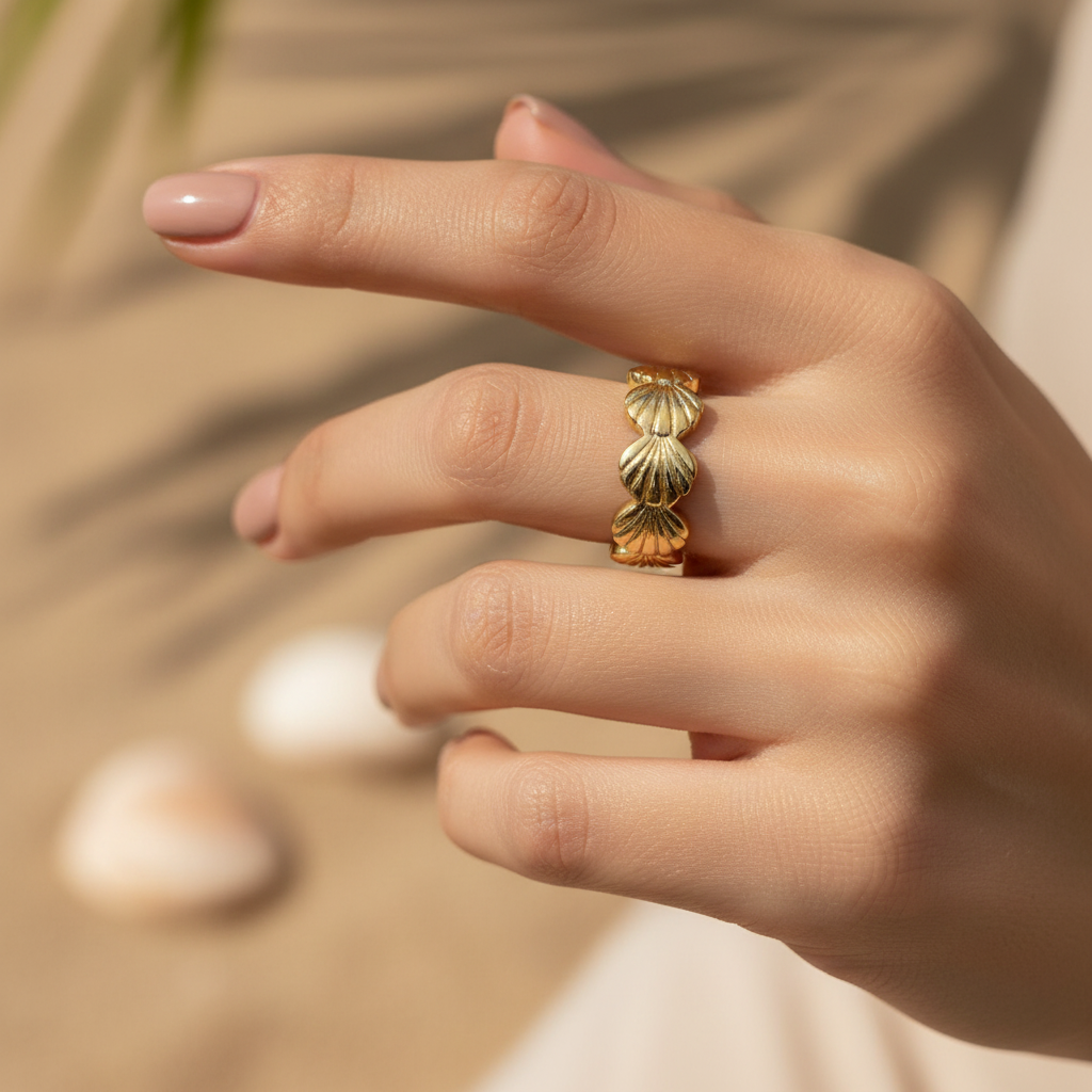 Gold seashell band open ring worn on woman's finger