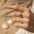 Gold seashell band open ring worn on woman's finger