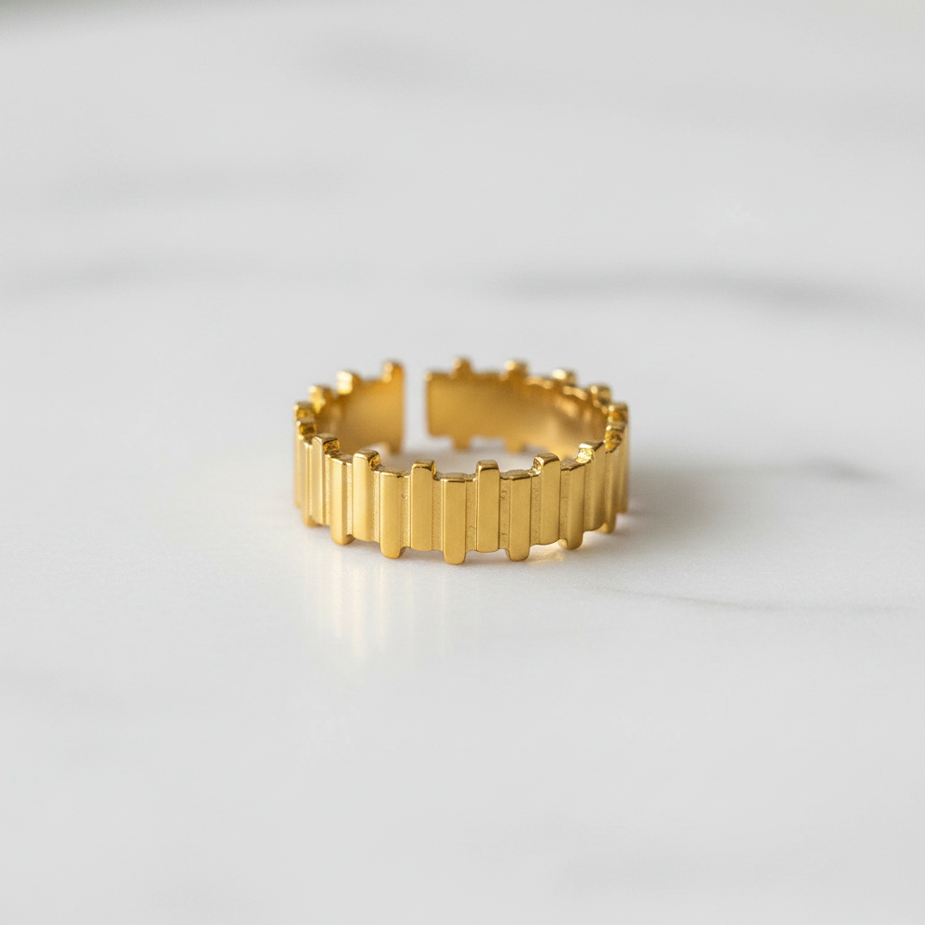 Gold vertical bar link wide band open cuff ring on white marble surface