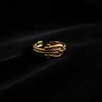 Gold belt buckle braided chain open cuff ring on black velvet with dramatic rim lighting