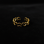 Gold open heart cutout band open cuff ring on black velvet with dramatic rim lighting