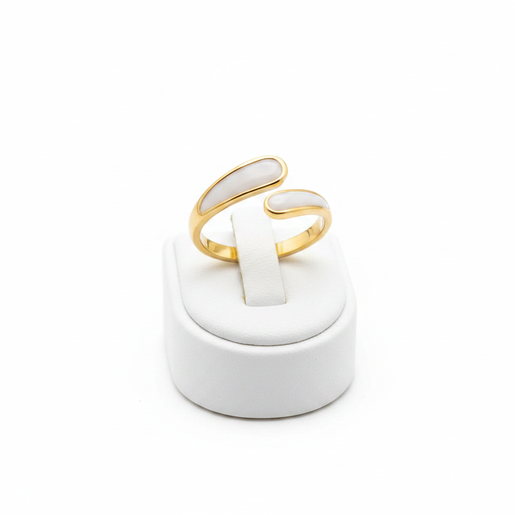 Gold and white stone bypass open cuff ring on white jewelry stand, clean studio shot