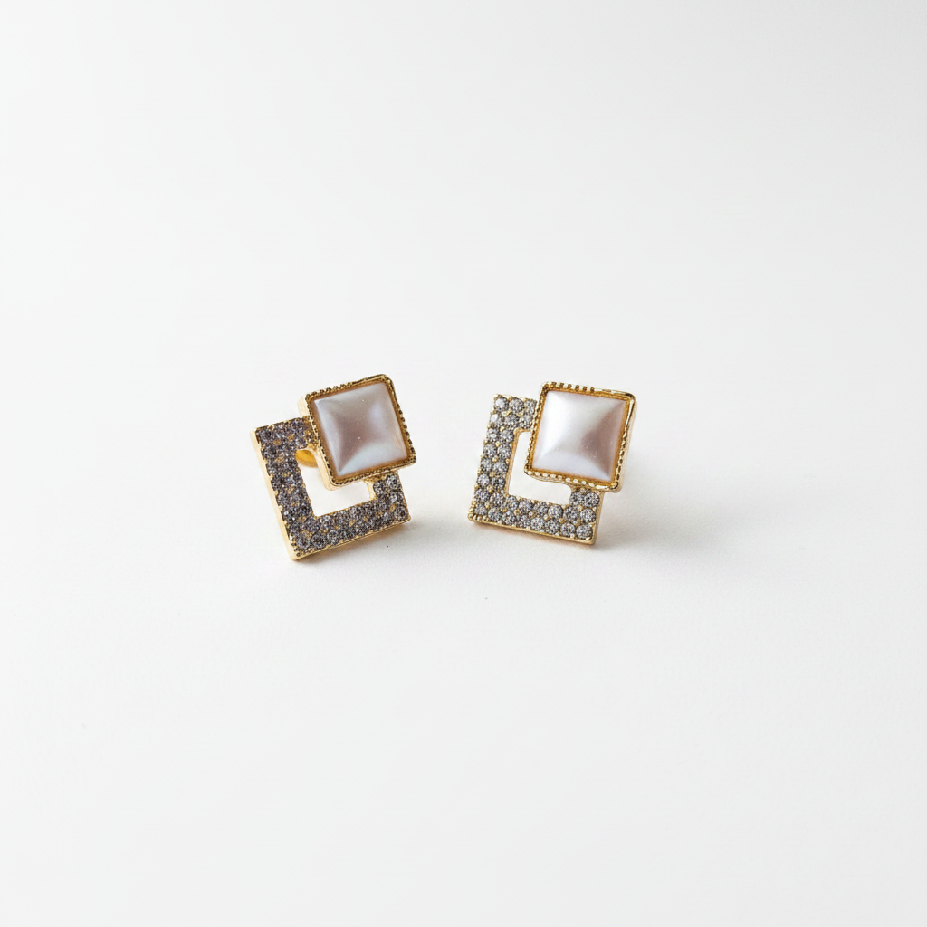 Violet Vows square gold stud earrings featuring a pearl center and paved crystals in a product shot on white.