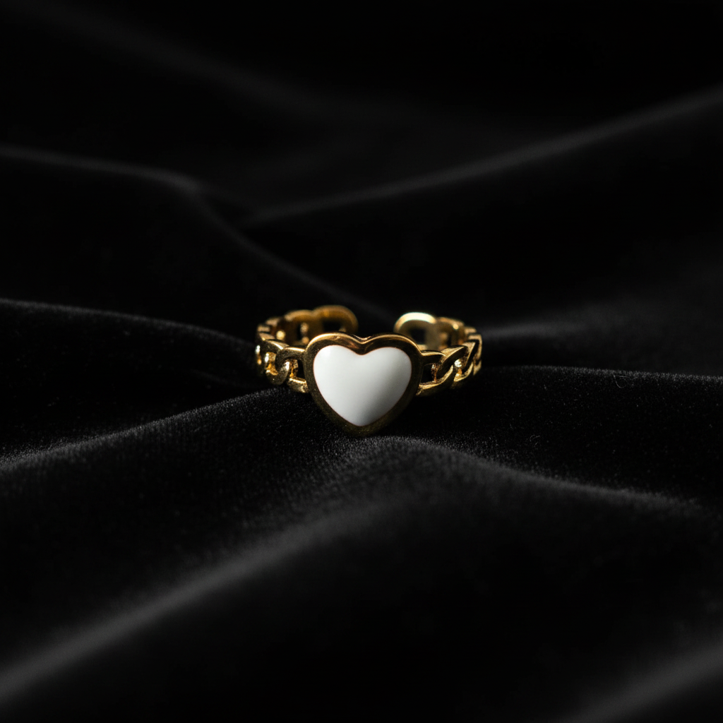 Gold chain link band white enamel heart open cuff ring on black velvet with dramatic rim lighting