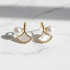 Pearl & Shell Fan Stud Earrings on white marble flat lay