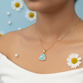 Model wearing light blue triangular enamel pendant necklace with white pearl and CZ leaf accent on gold oval link chain - jewelry by Violet Vows