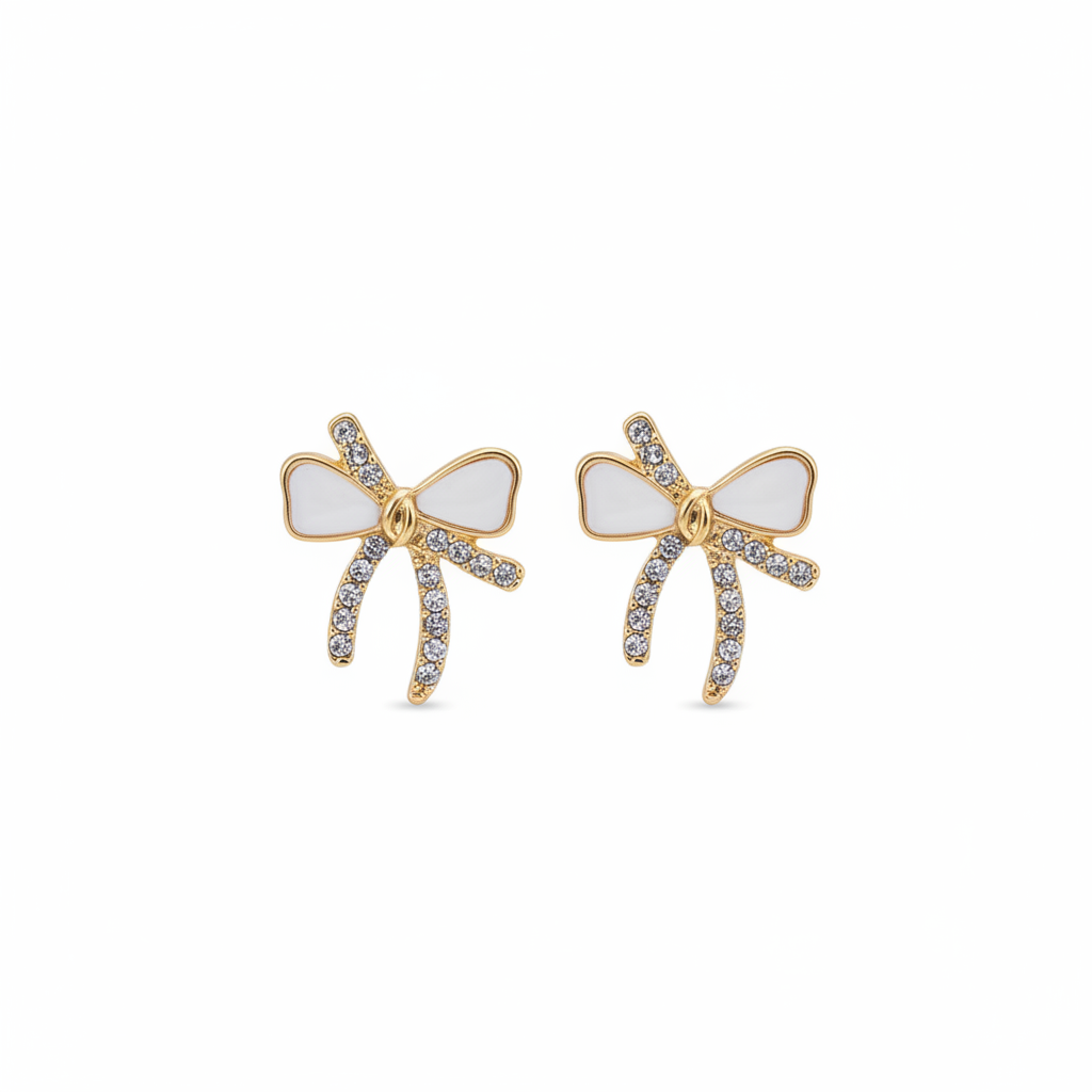 Violet Vows gold bow stud earrings featuring white enamel and crystal pave tails in a product shot on white.