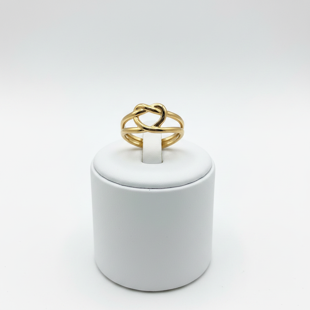 Gold heart cutout open cuff ring on white jewelry stand, clean studio shot