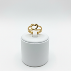 Gold heart cutout open cuff ring on white jewelry stand, clean studio shot