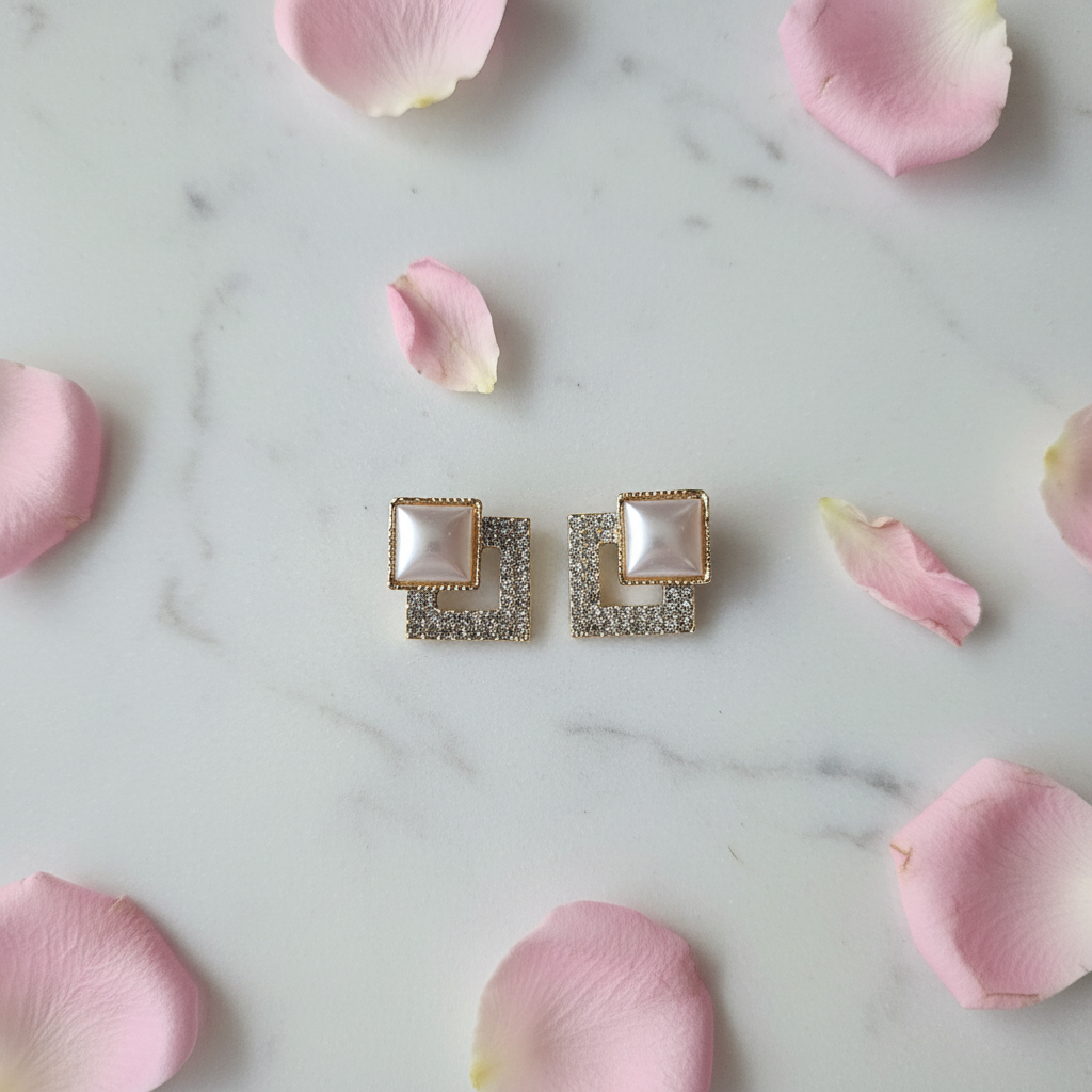 Violet Vows square pearl stud earrings styled flat lay with pink rose petals on white marble.