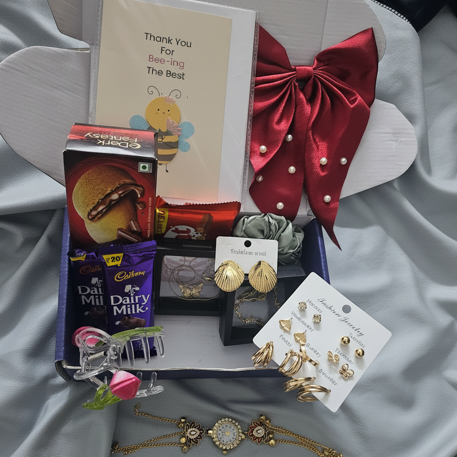 Violet Vows gift packaging shot containing gold-tone jewelry, necklaces, earrings, chocolates, and accessories