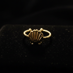 Gold seashell twisted rope open cuff ring on black velvet with dramatic rim lighting