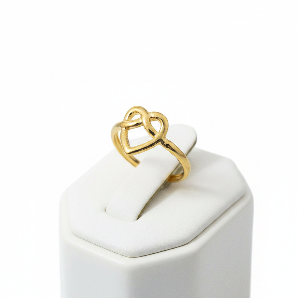 Gold infinity heart open cuff ring on white jewelry stand, clean studio shot