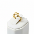 Gold infinity heart open cuff ring on white jewelry stand, clean studio shot