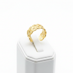 Gold infinity knot weave open cuff ring on white jewelry stand, clean studio shot