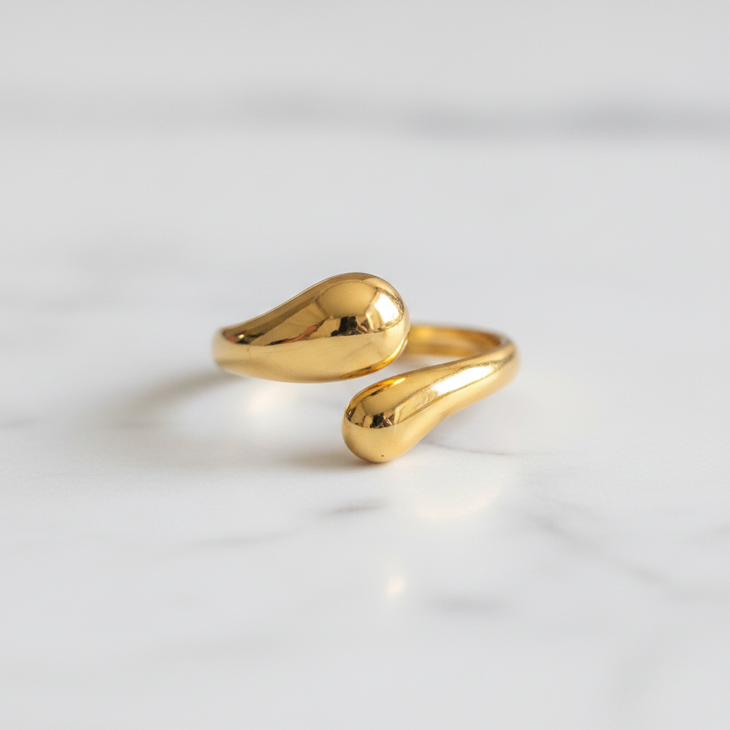 Gold teardrop dome bypass open cuff ring on white marble surface