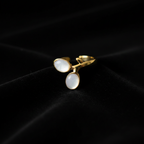 Gold double oval stone bypass open cuff ring on black velvet with dramatic lighting