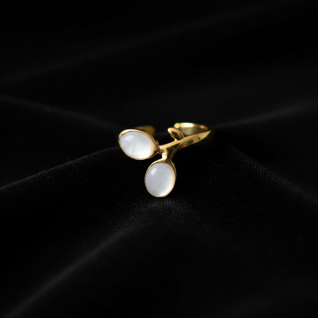 Gold double oval stone bypass open cuff ring on black velvet with dramatic lighting