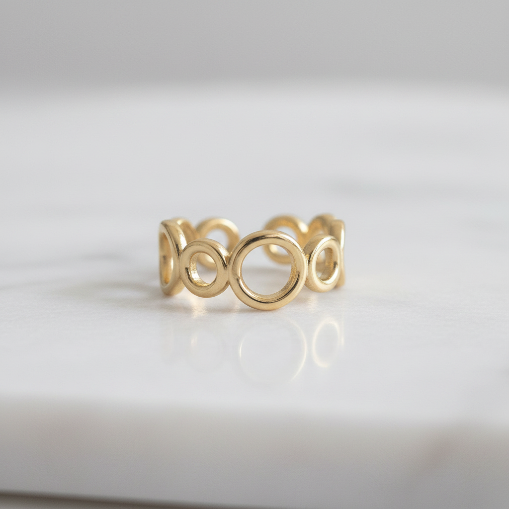 Gold open circle link band open cuff ring on white marble surface