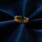 Gold crown battlements ring on navy blue velvet fabric