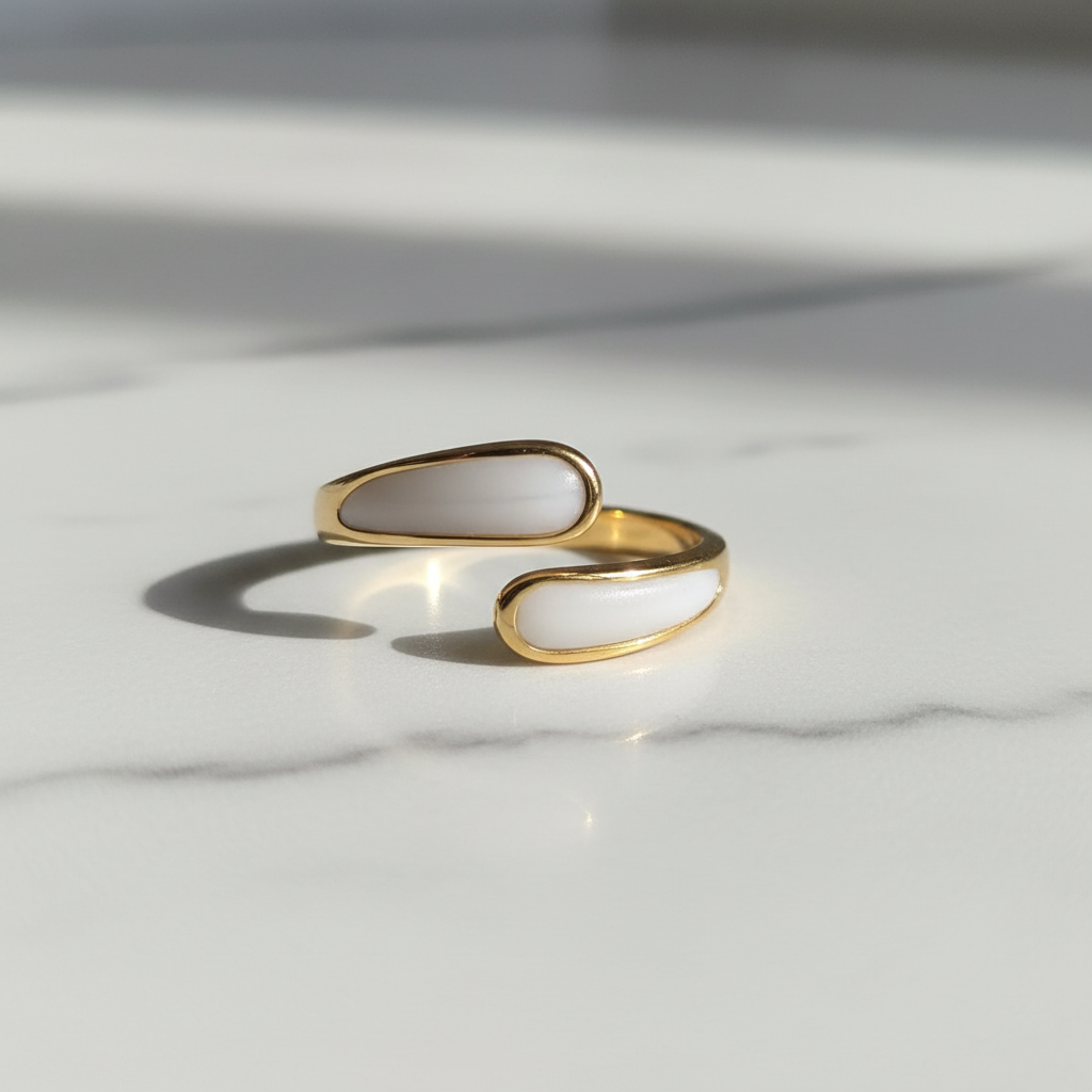 Gold and white stone bypass open cuff ring on white marble surface