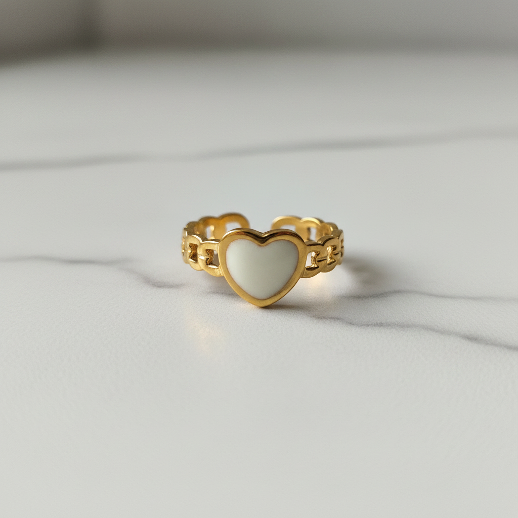 Gold chain link band white enamel heart open cuff ring on white marble surface