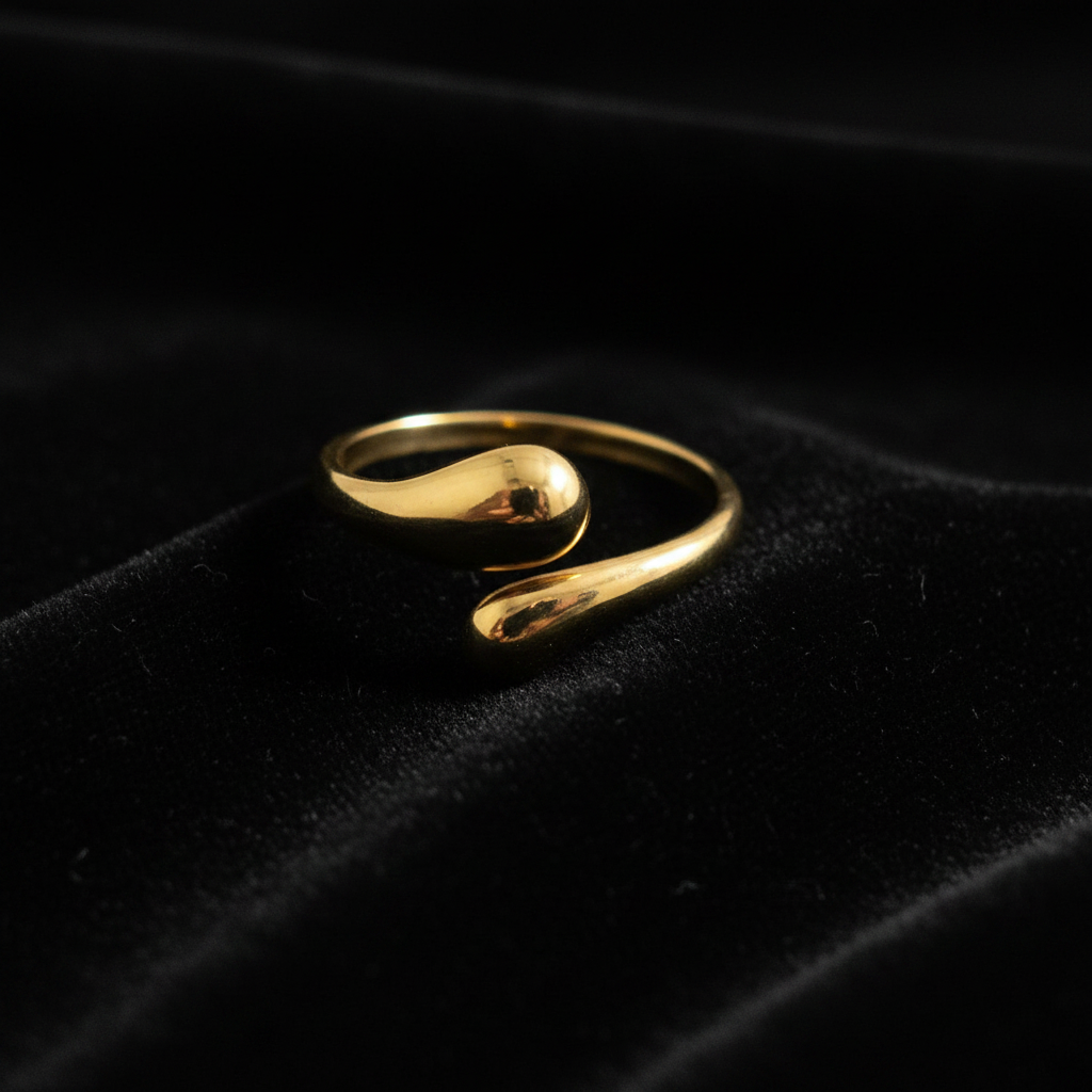 Gold teardrop dome bypass open cuff ring on black velvet with dramatic rim lighting