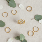 Gold open circle link band open cuff ring on ivory linen with gold rings and eucalyptus