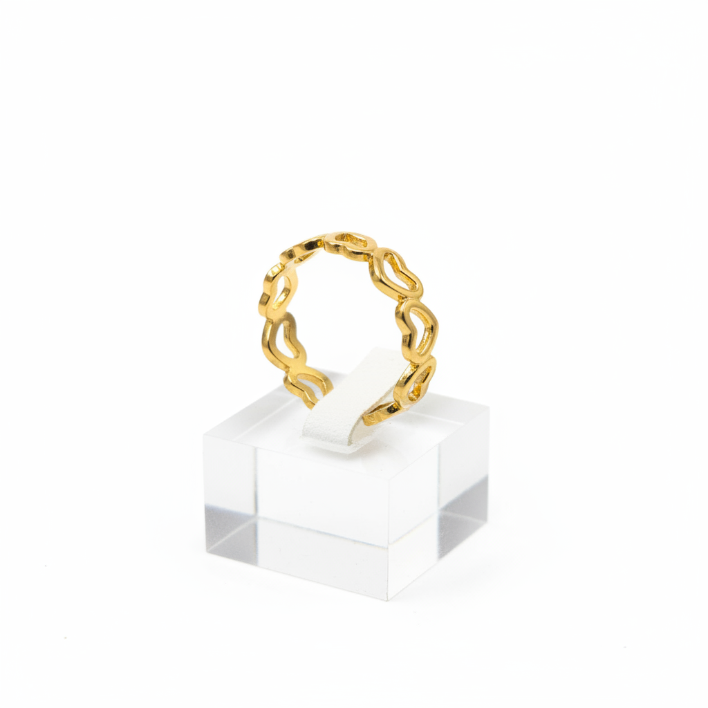 Gold open heart cutout band open cuff ring on white jewelry stand, clean studio shot