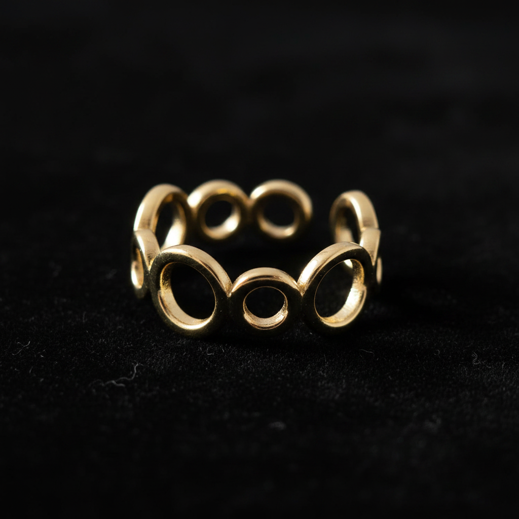 Gold open circle link band open cuff ring on black velvet with dramatic rim lighting