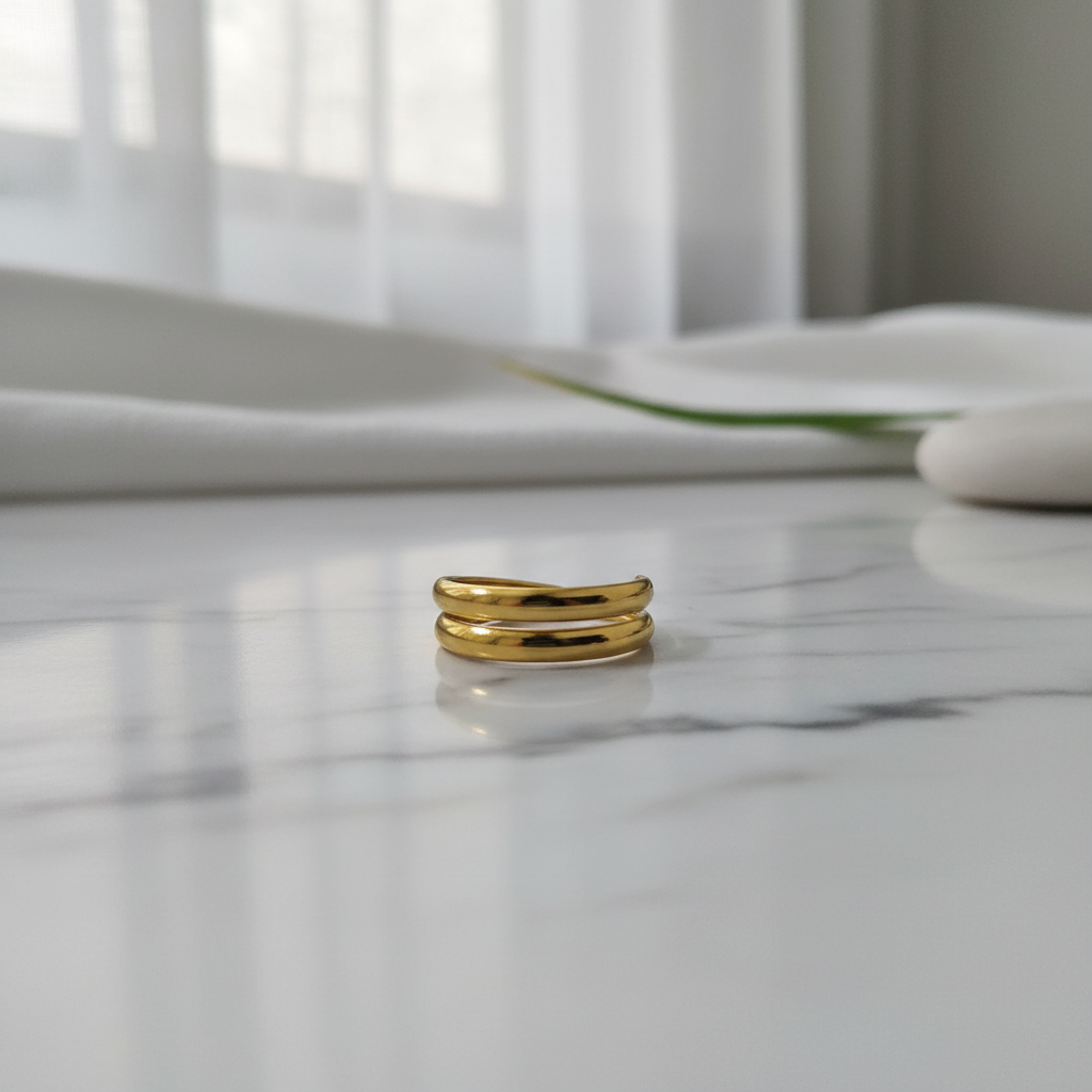 Gold double layer open band ring on white marble surface