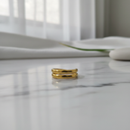 Gold double layer open band ring on white marble surface