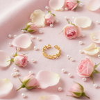 Gold open heart cutout band open cuff ring on blush pink linen with rose petals and pearls