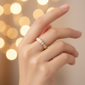Gold white oval enamel wide band open cuff ring worn on finger with warm golden bokeh