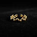 Gold beaded bubble band open cuff ring on black velvet with dramatic rim lighting