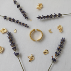Gold crown battlements ring flat lay with dried lavender and gold foil accents
