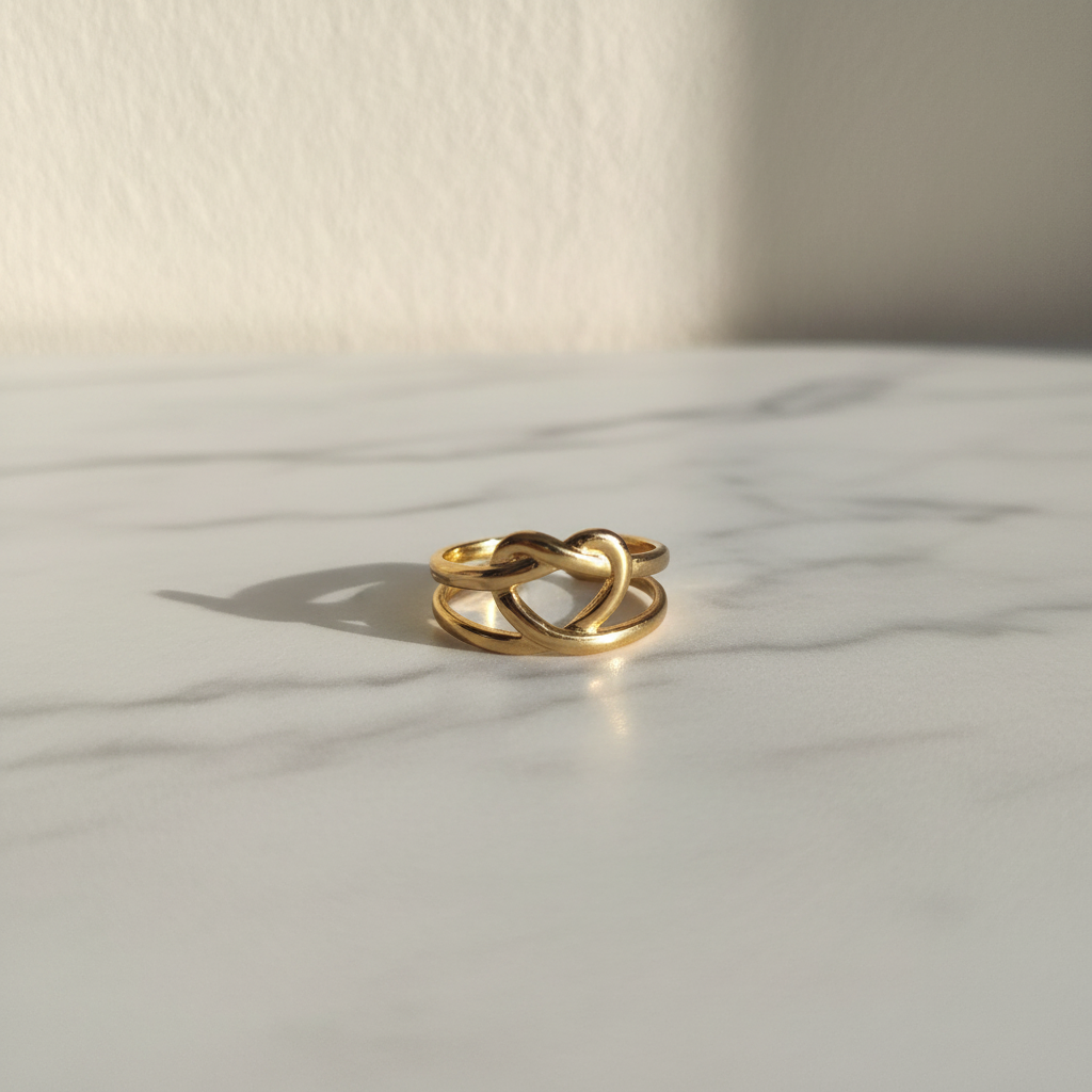 Gold heart cutout open cuff ring on white marble surface